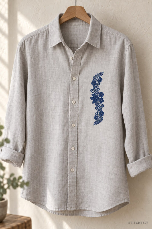 Generated usage mockup of a linen shirt with the leaf capped floral scroll machine embroidery motif in one deep midnight indigo blue thread color.