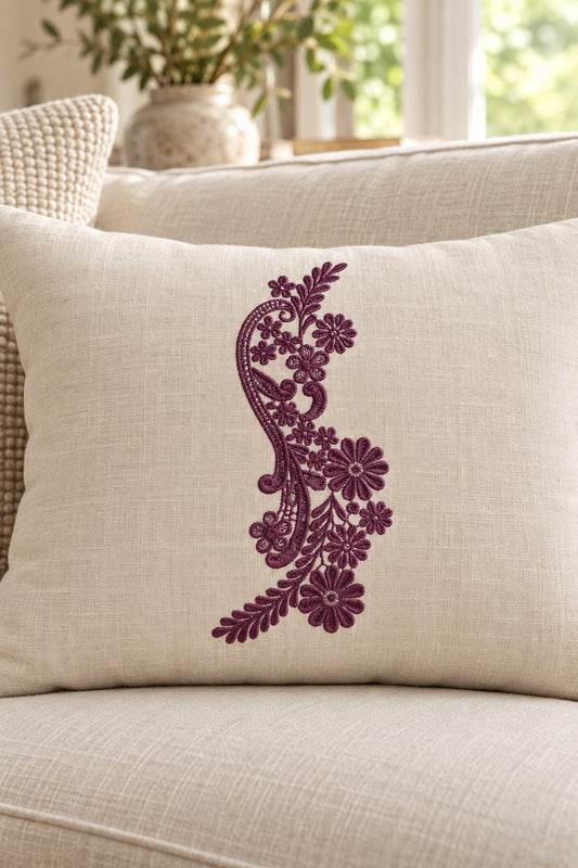 Photorealistic paisley wildflower spray machine embroidery in deep mulberry thread on a linen lumbar cushion, shown as one fabric-stitched motif