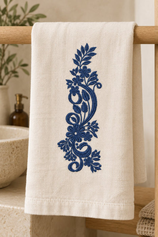 Single-color Prussian blue floral paisley machine embroidery on a folded warm white guest towel