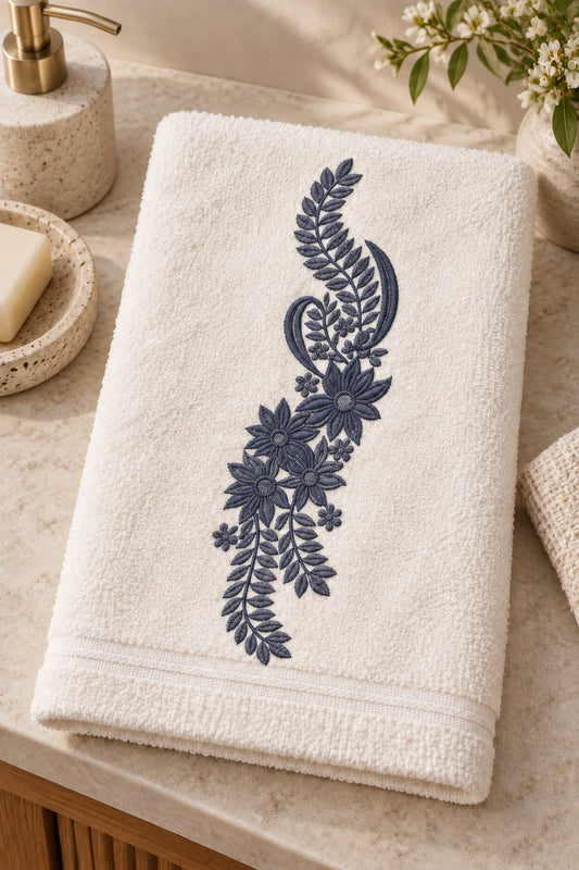 Single-color smoked-indigo botanical paisley machine embroidery on a white guest towel