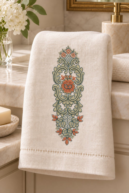 Three-color rose cartouche machine embroidery placed vertically on a warm white guest towel