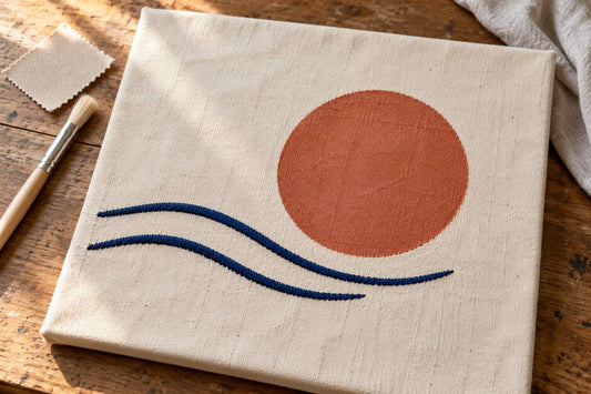Terracotta painted disc and navy embroidered curves on cream cotton canvas