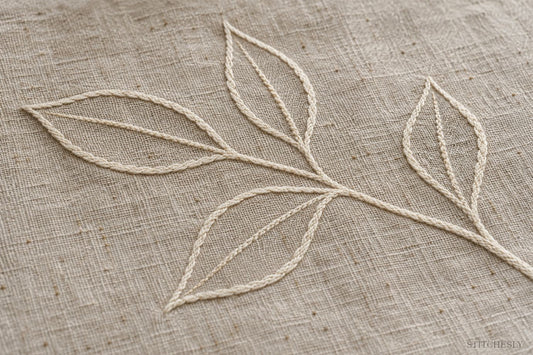 Ivory stitched leaf outlines with open unstitched centres on natural linen