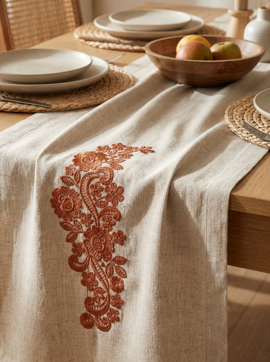 White pillow decorated with a bold red vertical floral border embroidery design featuring flowers, leaves and scrolls.