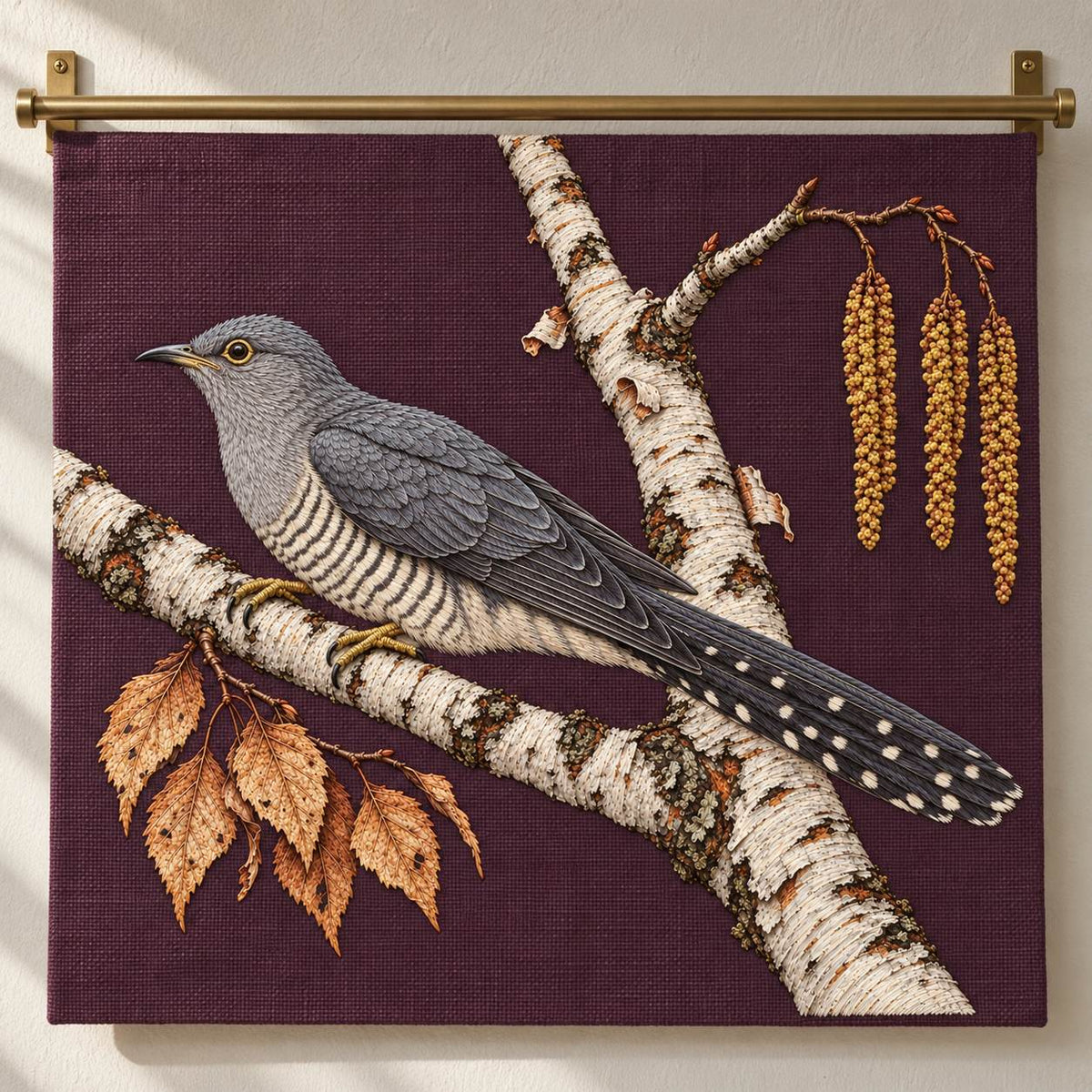 Cuckoo Beyond the Birch Fork visual mockup shown as a hanging textile held by wooden rails, with the design on burgundy linen.