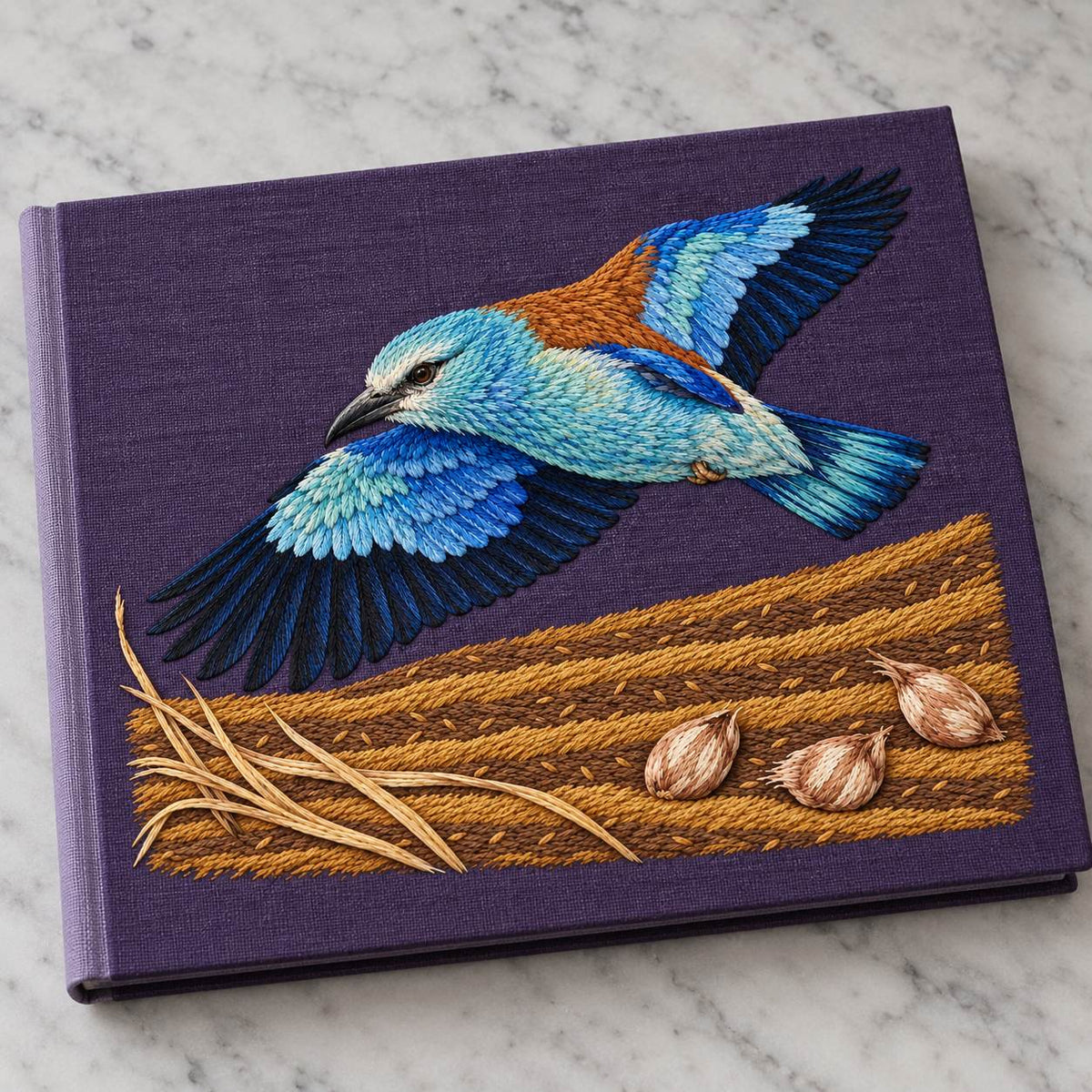 Roller Above the Saffron Field Break visual mockup shown on a cloth portfolio cover, with the design on plum linen.