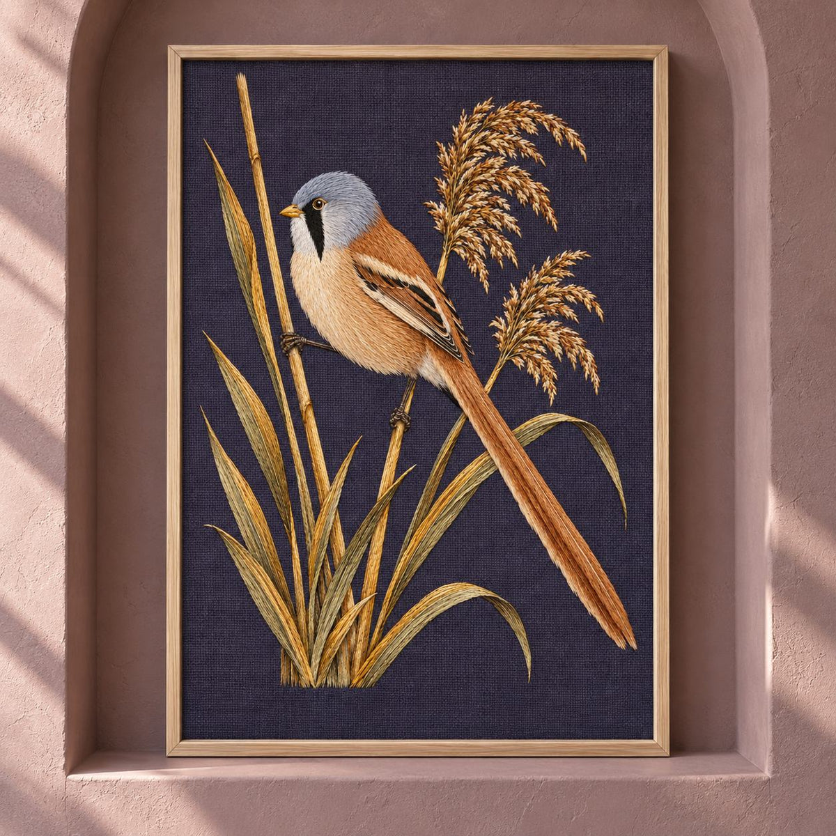 Bearded Reedling in the Amber Fan visual mockup shown as a framed textile in a gallery niche, with the design on deep plum linen.