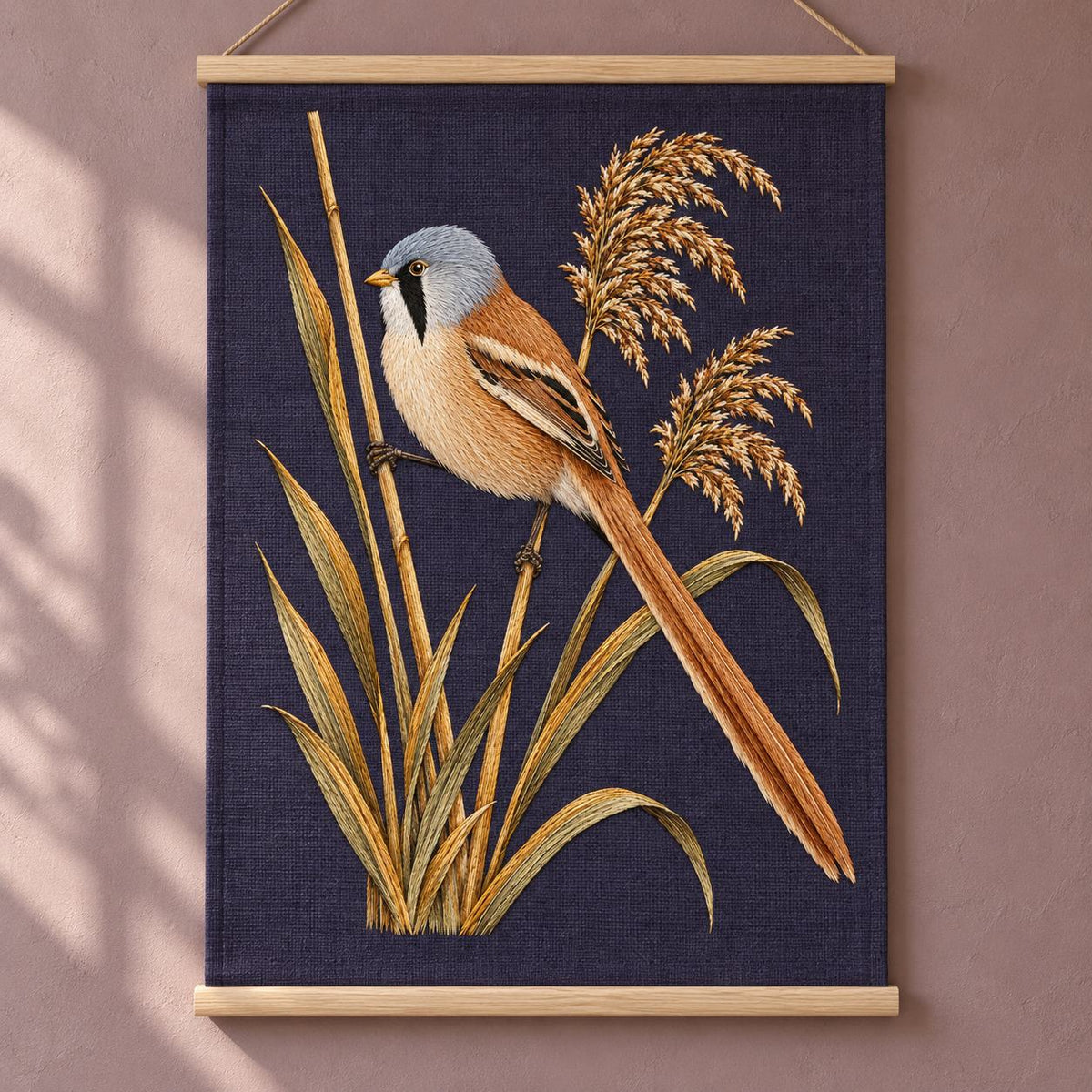 Bearded Reedling in the Amber Fan visual mockup shown as a hanging textile held by wooden rails, with the design on deep plum linen.