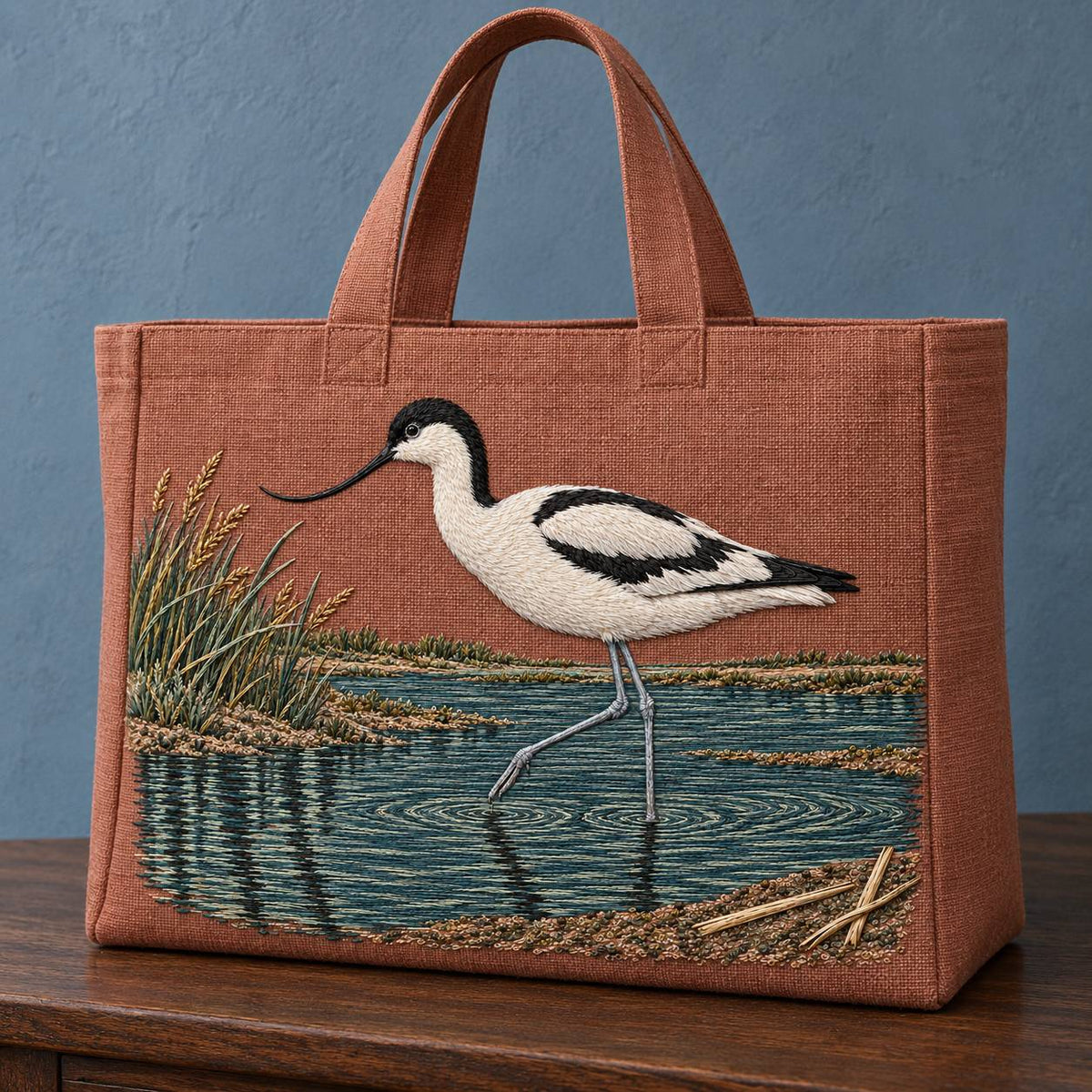 Avocet Across the Blackwater Line visual mockup shown on the front of a structured linen tote, with the design on dusty terracotta linen.