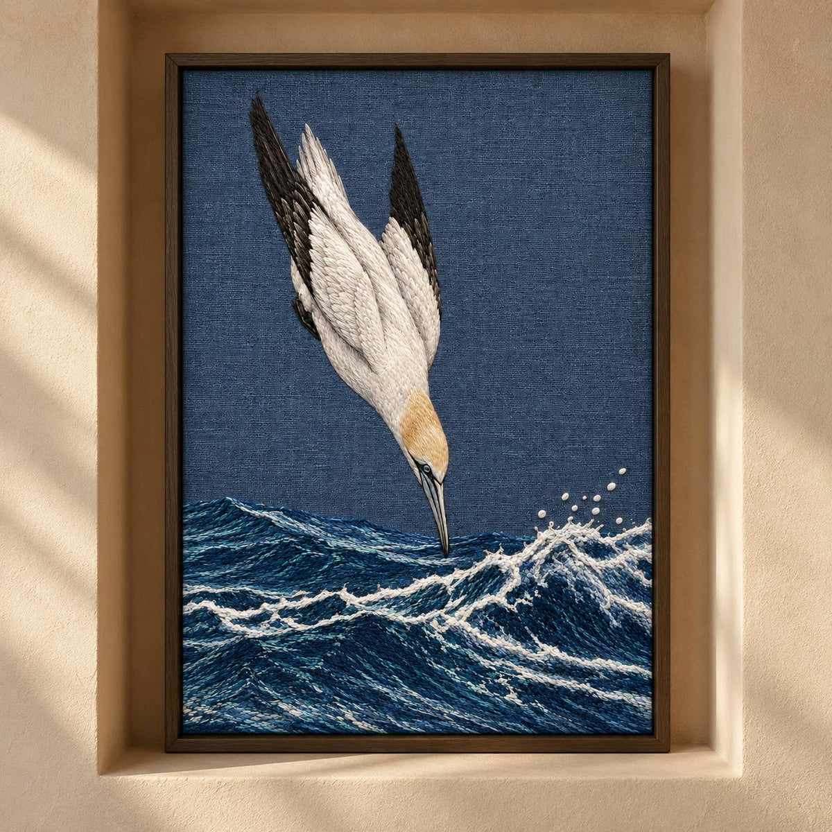 Gannet in the Whitewater Plunge visual mockup shown as a framed textile in a gallery niche, with the design on slate-blue linen.