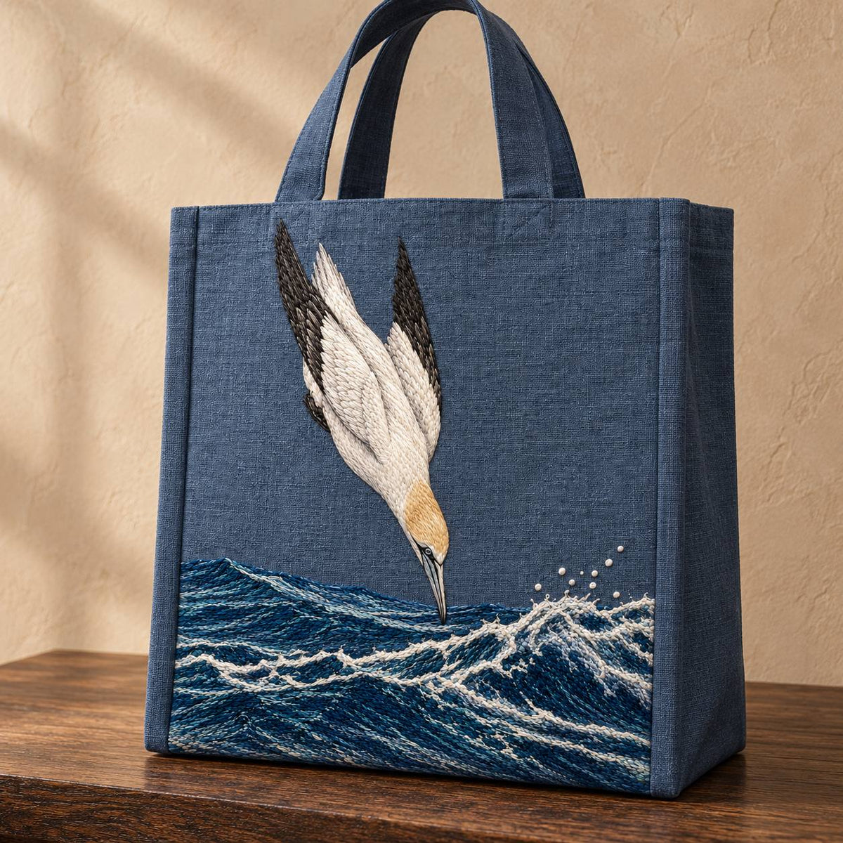 Gannet in the Whitewater Plunge visual mockup shown on the front of a structured linen tote, with the design on slate-blue linen.