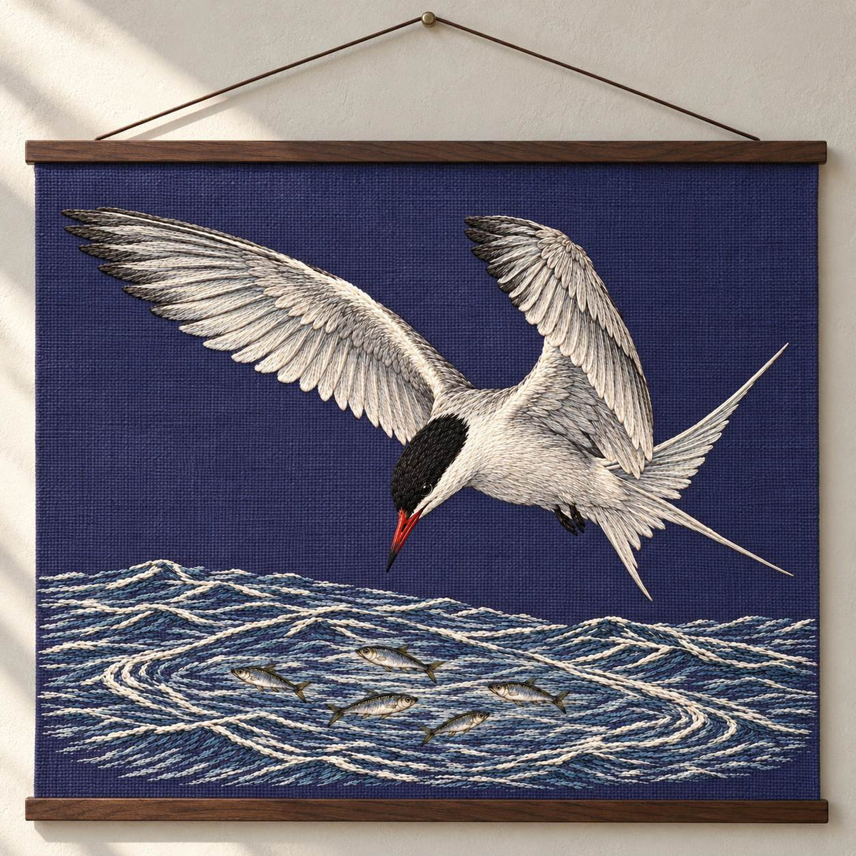 Common Tern Above the Silver Shoal visual mockup shown as a hanging textile held by wooden rails, with the design on deep blue-violet linen.