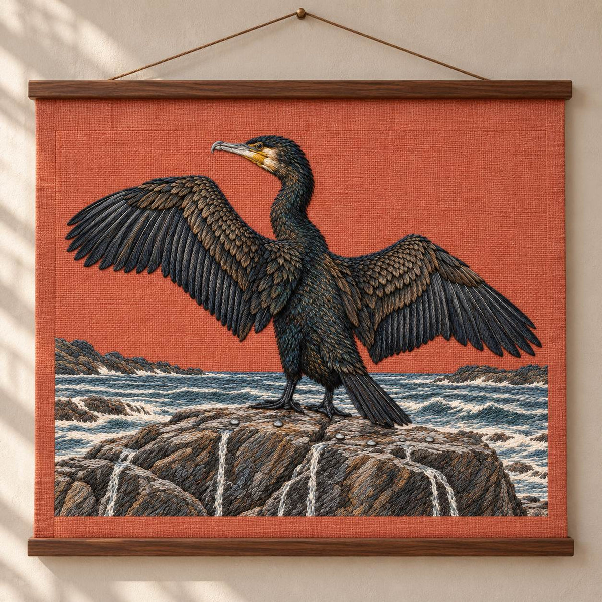 Cormorant Opening the Rain Black Wings visual mockup shown as a hanging textile held by wooden rails, with the design on muted rust linen.