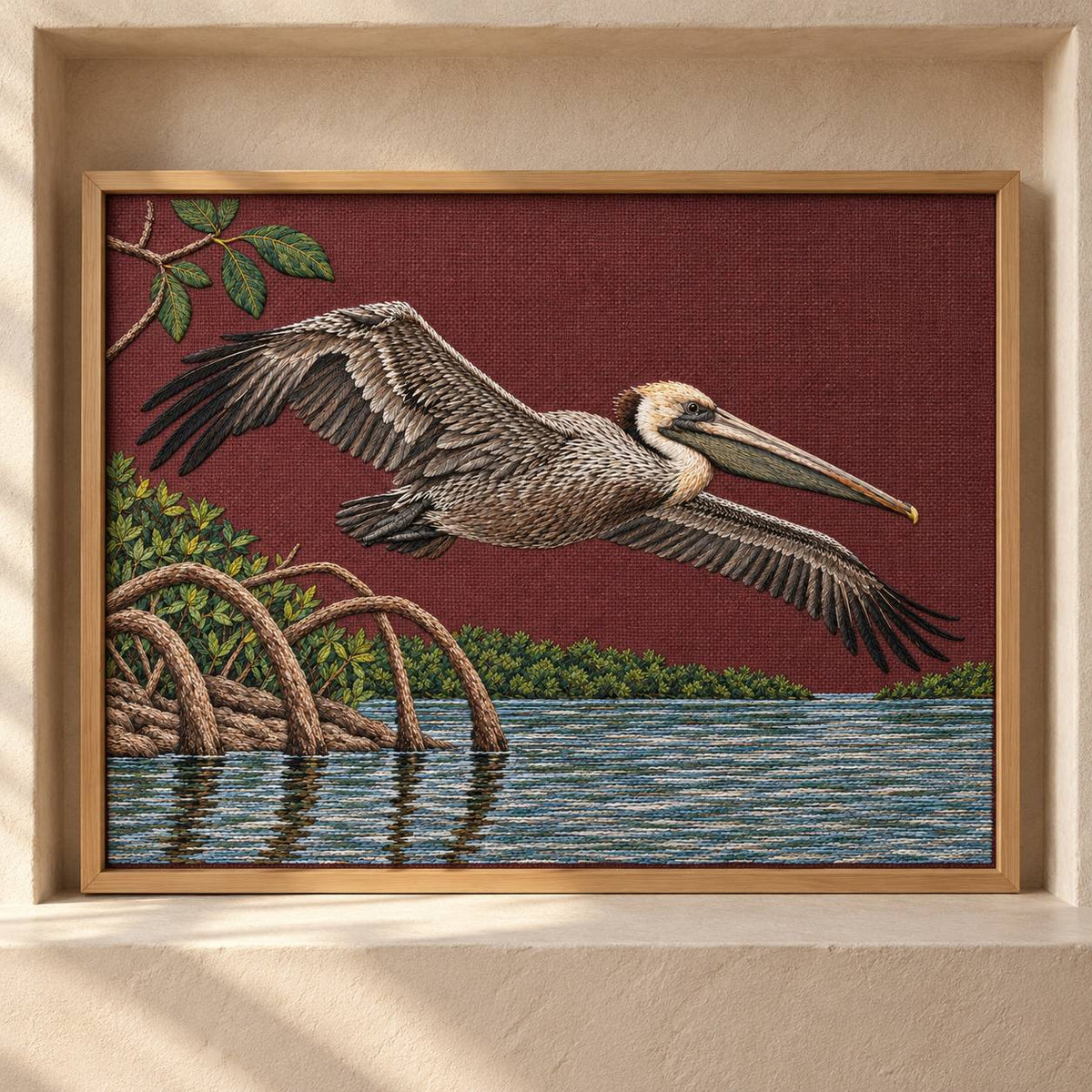 Pelican Over the Mangrove Mirror visual mockup shown as a framed textile in a gallery niche, with the design on deep burgundy linen.
