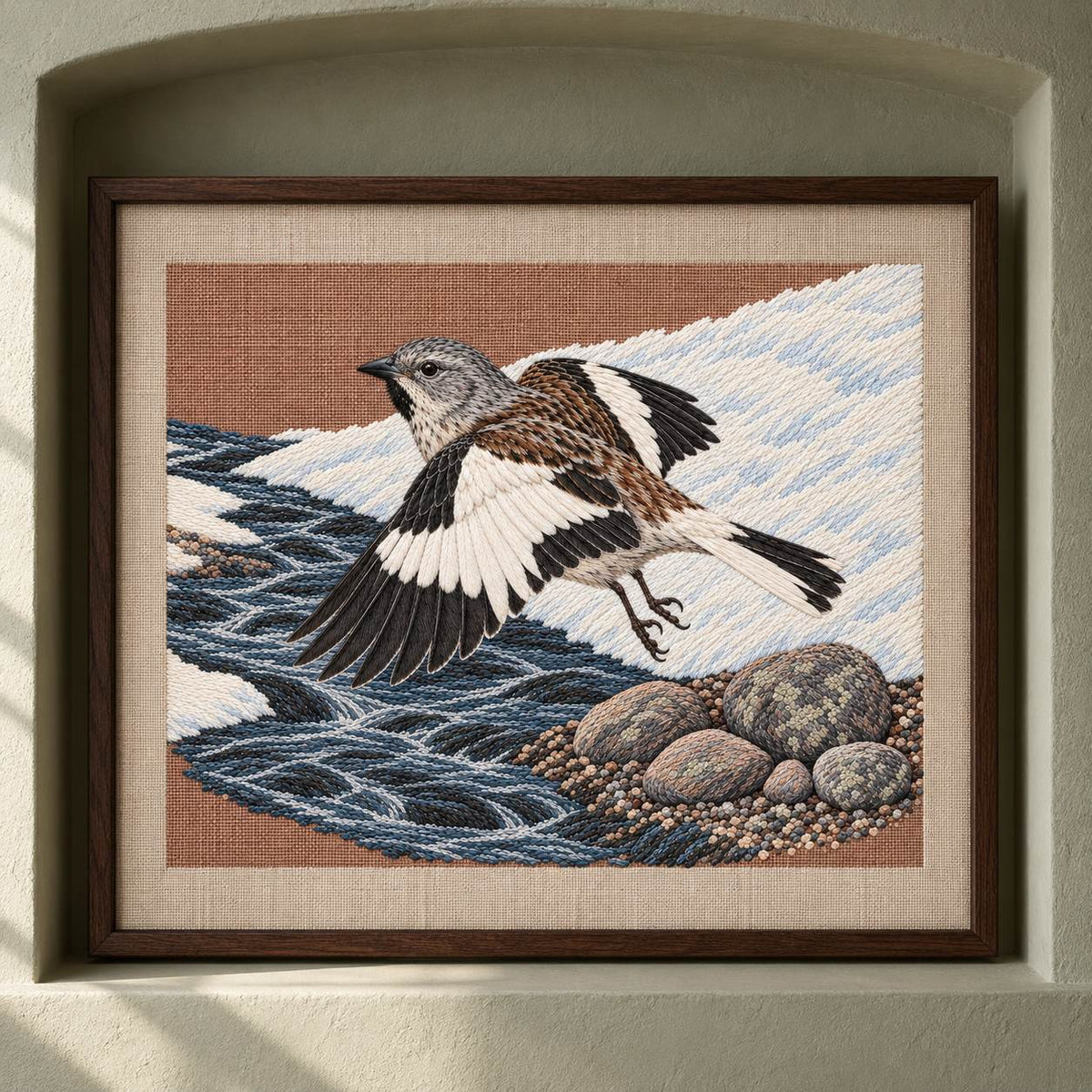 Snowfinch Along the Meltwater Cut visual mockup shown as a framed textile in a gallery niche, with the design on warm oatmeal linen.