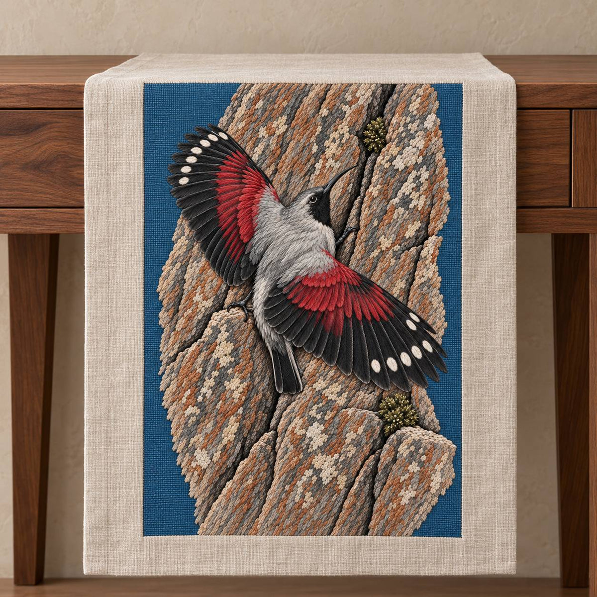 Wallcreeper on the Vermilion Cliff visual mockup shown on a textile runner over a console, with the design on slate-blue linen.