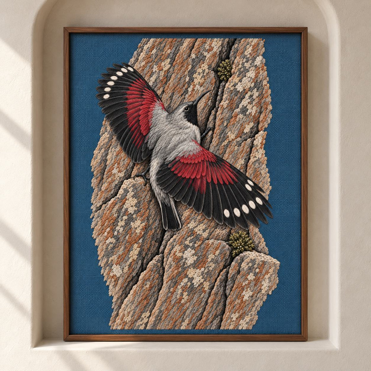 Wallcreeper on the Vermilion Cliff visual mockup shown as a framed textile in a gallery niche, with the design on slate-blue linen.