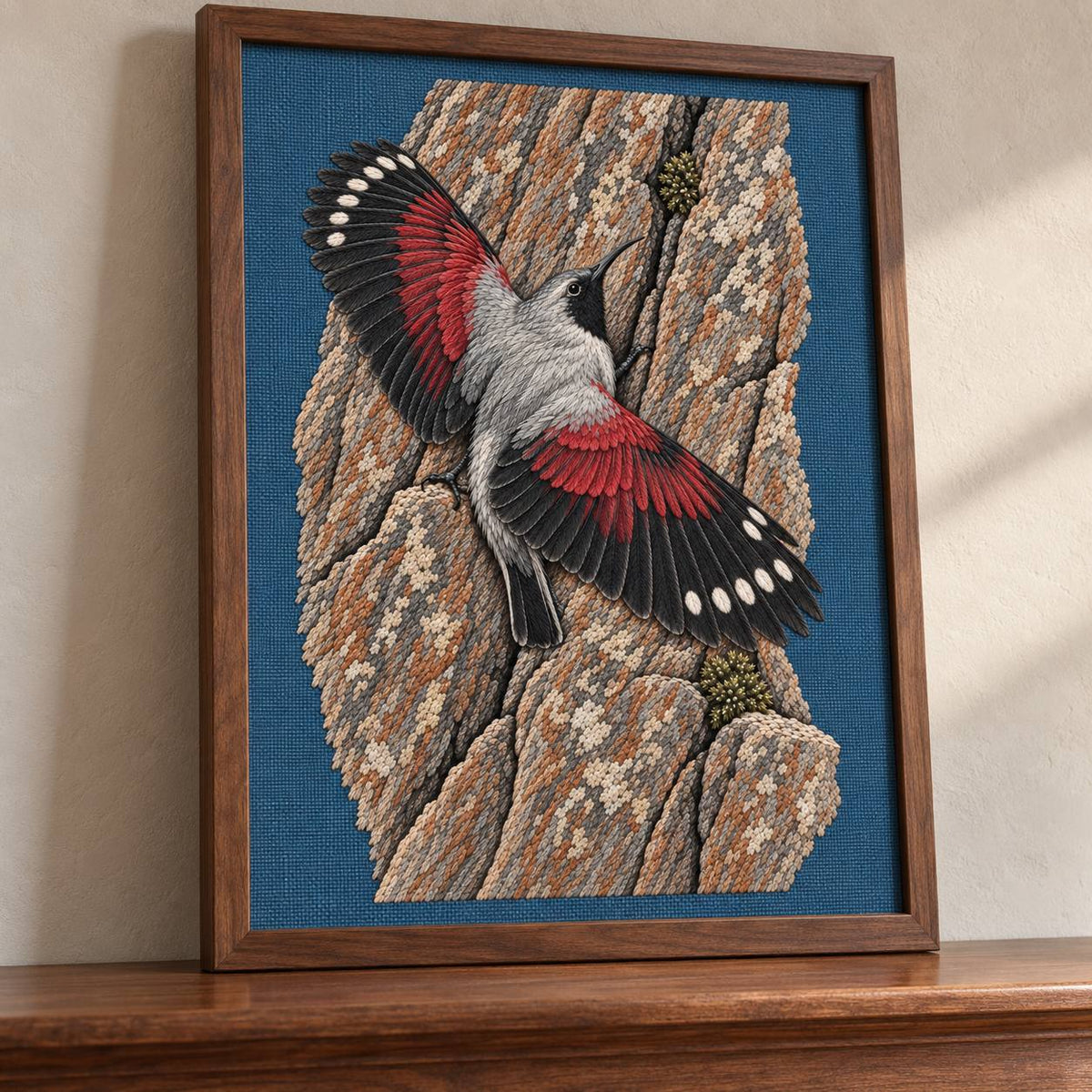 Wallcreeper on the Vermilion Cliff visual mockup shown in a frame leaning on a mantel, with the design on slate-blue linen.