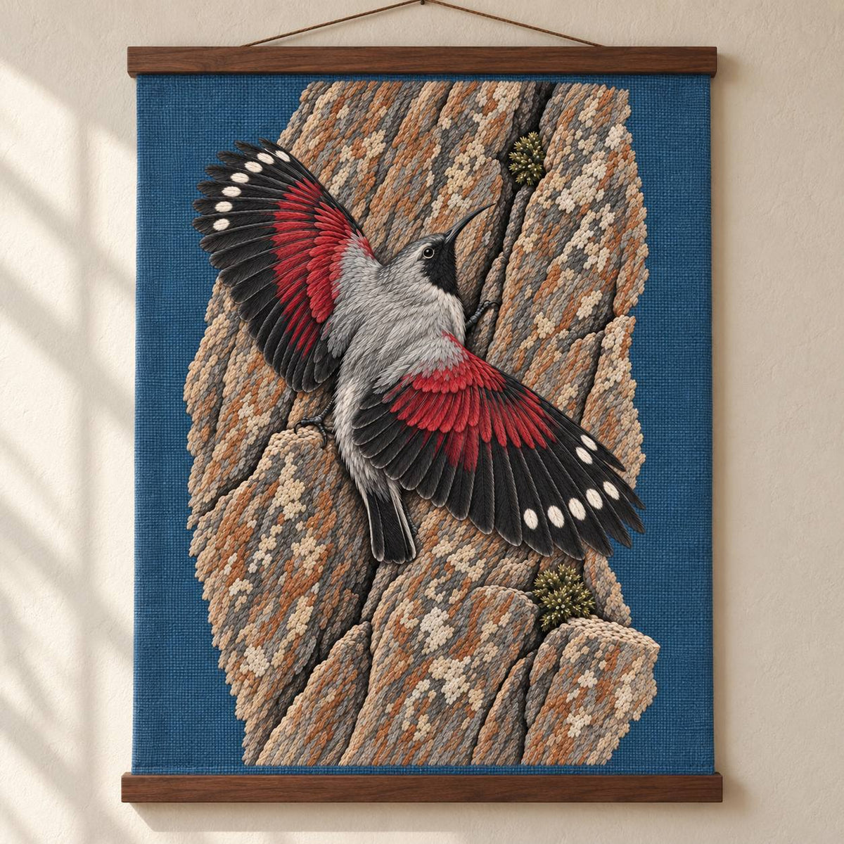 Wallcreeper on the Vermilion Cliff visual mockup shown as a hanging textile held by wooden rails, with the design on slate-blue linen.