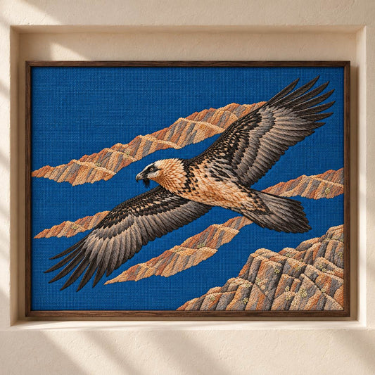Lammergeier Through the Ochre Updraft visual mockup shown as a framed textile in a gallery niche, with the design on deep blue linen.