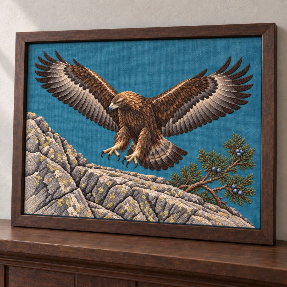 Golden Eagle Above the Juniper Shelf visual mockup shown in a frame leaning on a mantel, with the design on teal-blue linen.