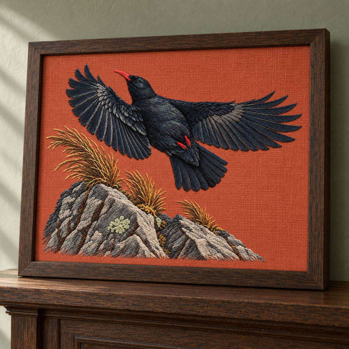 Chough at the Red Summit Flag visual mockup shown in a frame leaning on a mantel, with the design on muted rust linen.