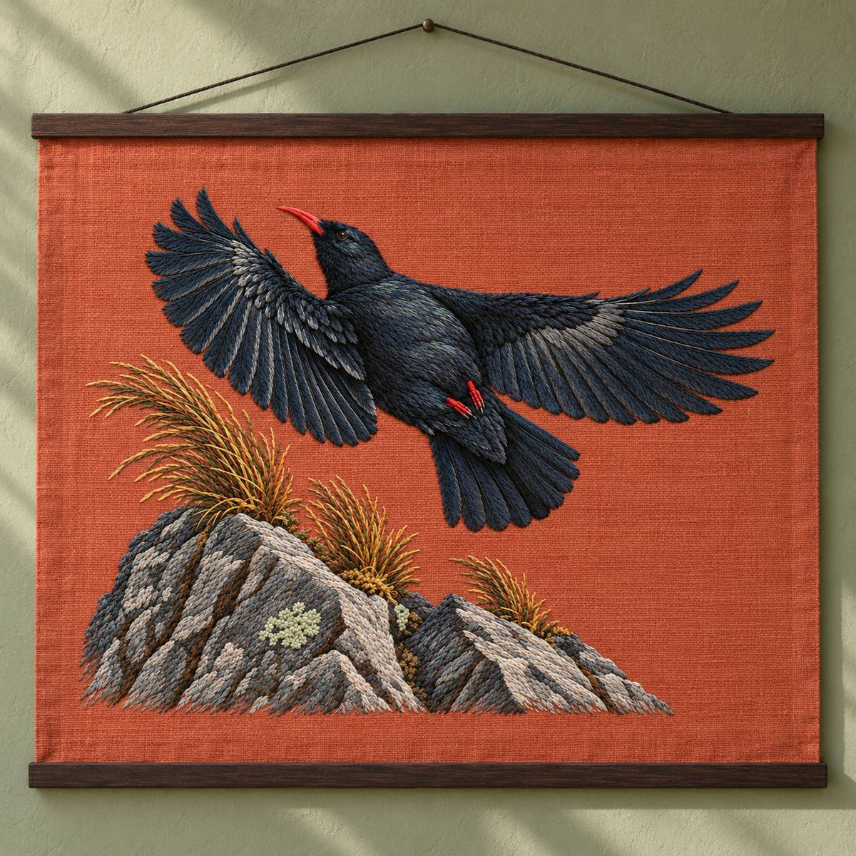 Chough at the Red Summit Flag visual mockup shown as a hanging textile held by wooden rails, with the design on muted rust linen.