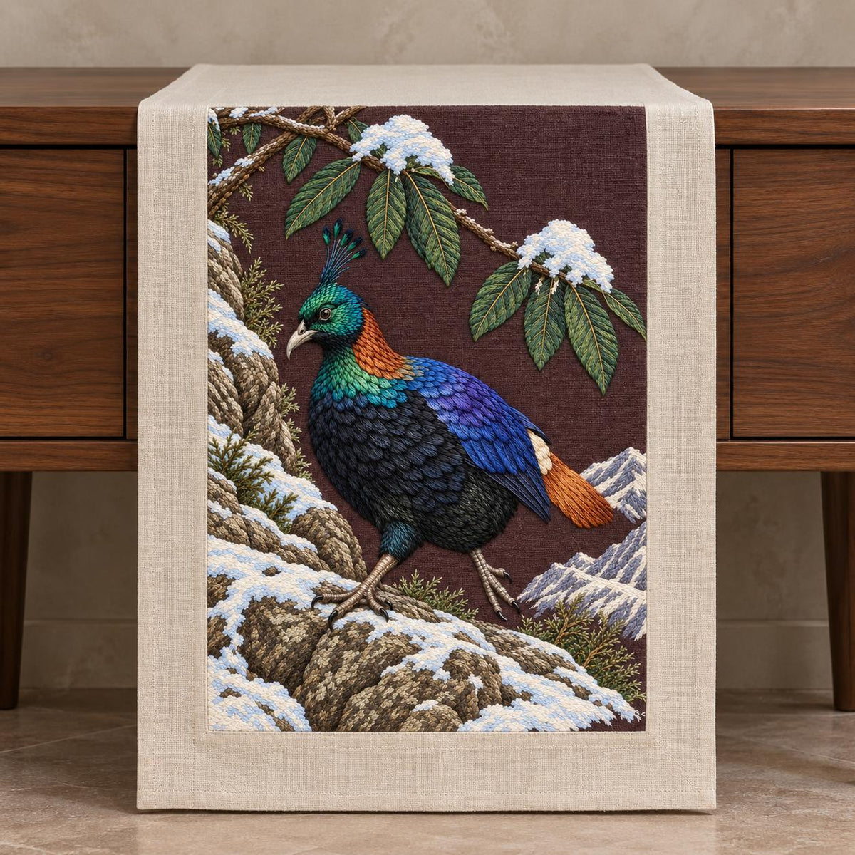 Monal Under the Rhododendron Snow visual mockup shown on a textile runner over a console, with the design on deep plum-brown linen.