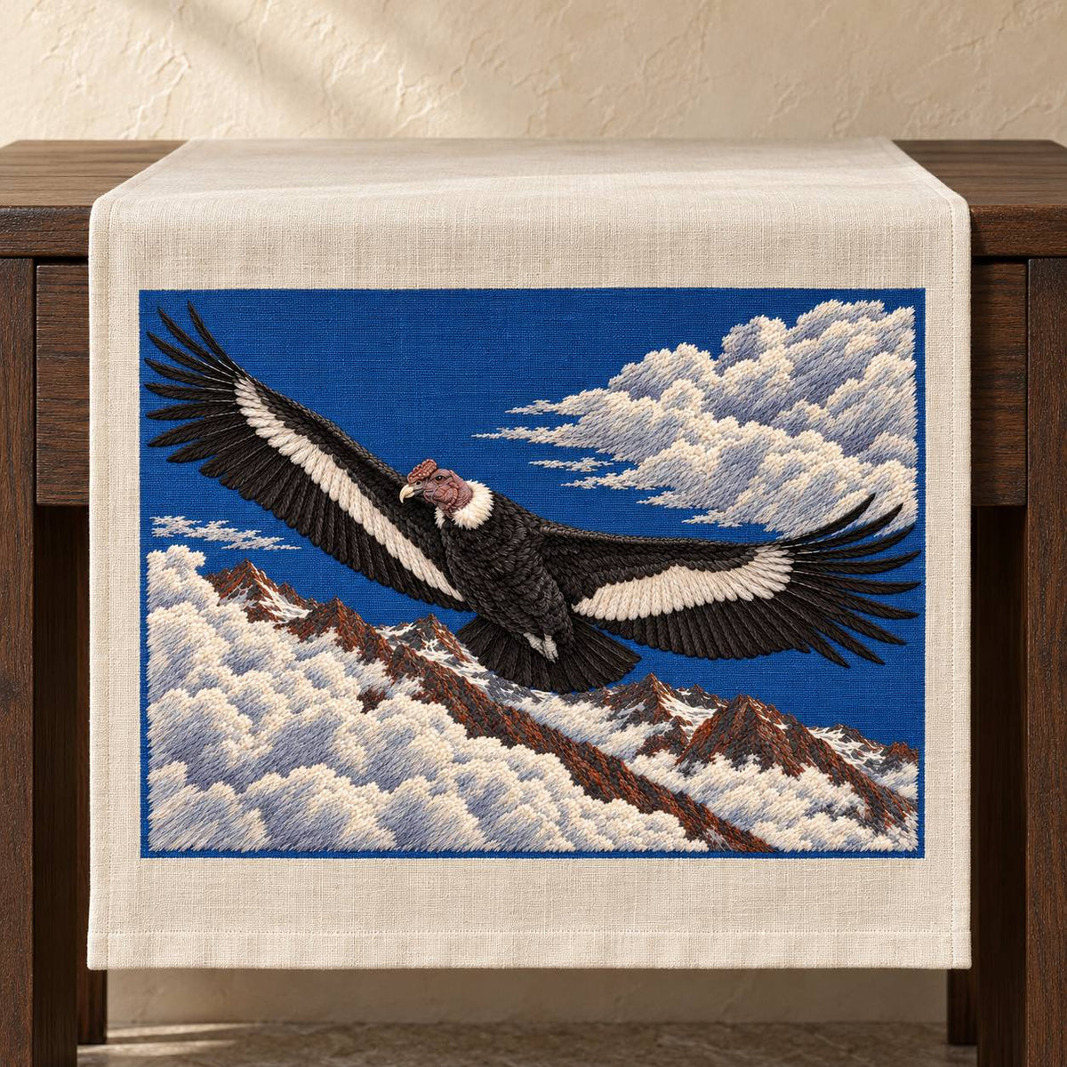 Condor Beyond the High Cloud Gate visual mockup shown on a textile runner over a console, with the design on deep blue linen.