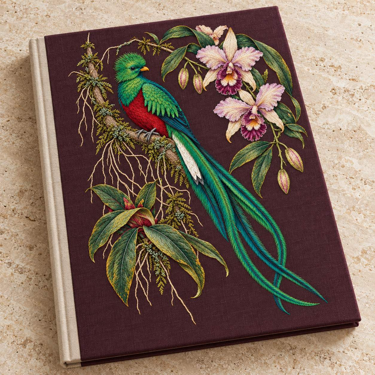 Quetzal Through the Orchid Arch visual mockup shown on a cloth portfolio cover, with the design on deep burgundy-plum linen.