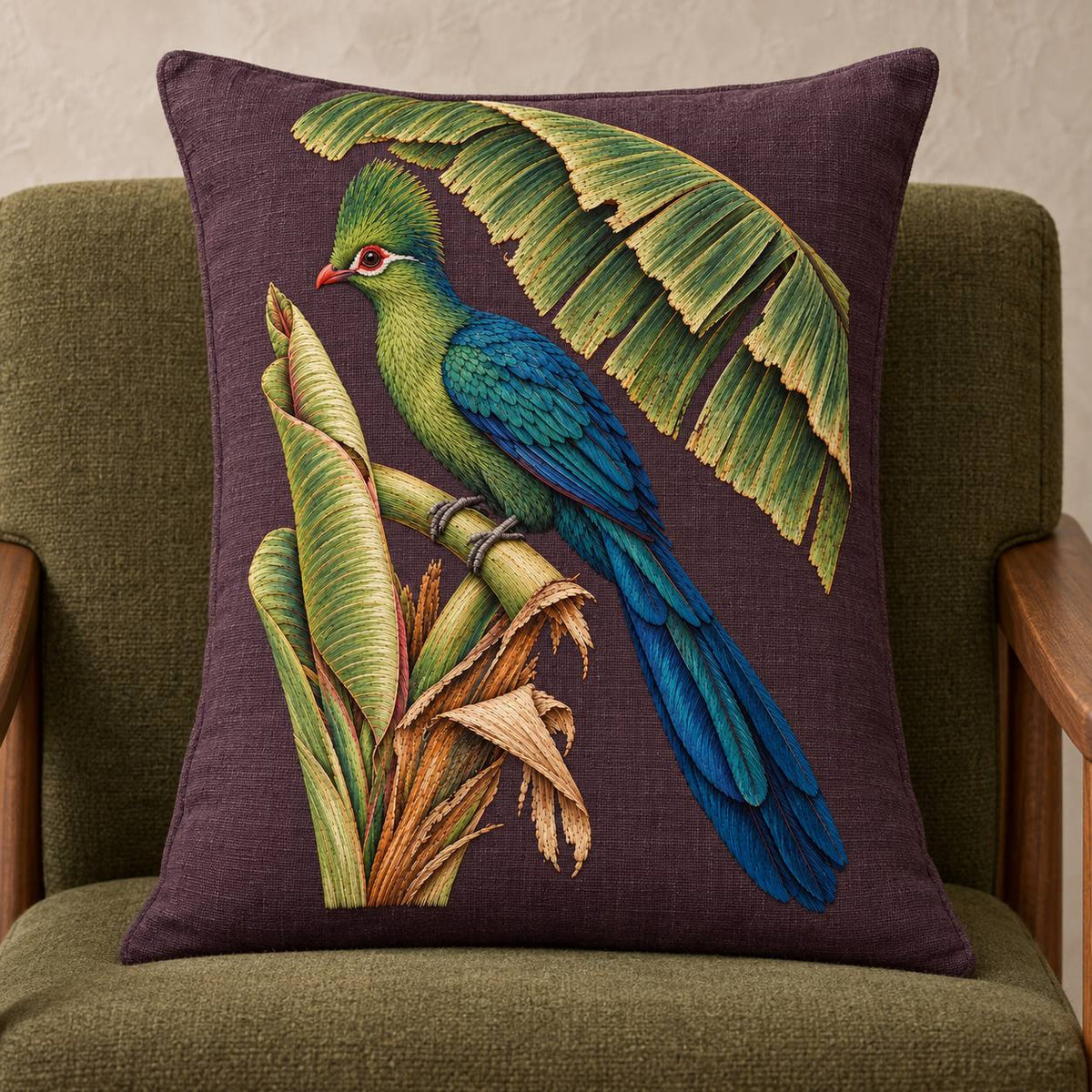 Turaco Beneath the Banana Rib Fan visual mockup shown on a cushion in a lounge chair, with the design on deep plum linen.