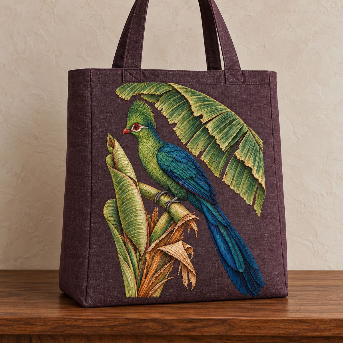 Turaco Beneath the Banana Rib Fan visual mockup shown on the front of a structured linen tote, with the design on deep plum linen.