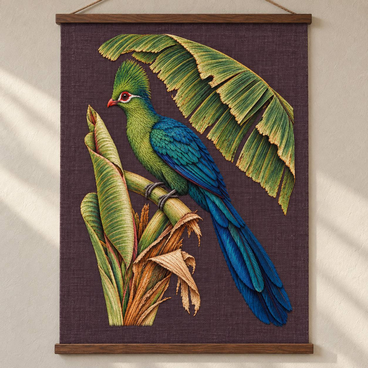 Turaco Beneath the Banana Rib Fan visual mockup shown as a hanging textile held by wooden rails, with the design on deep plum linen.