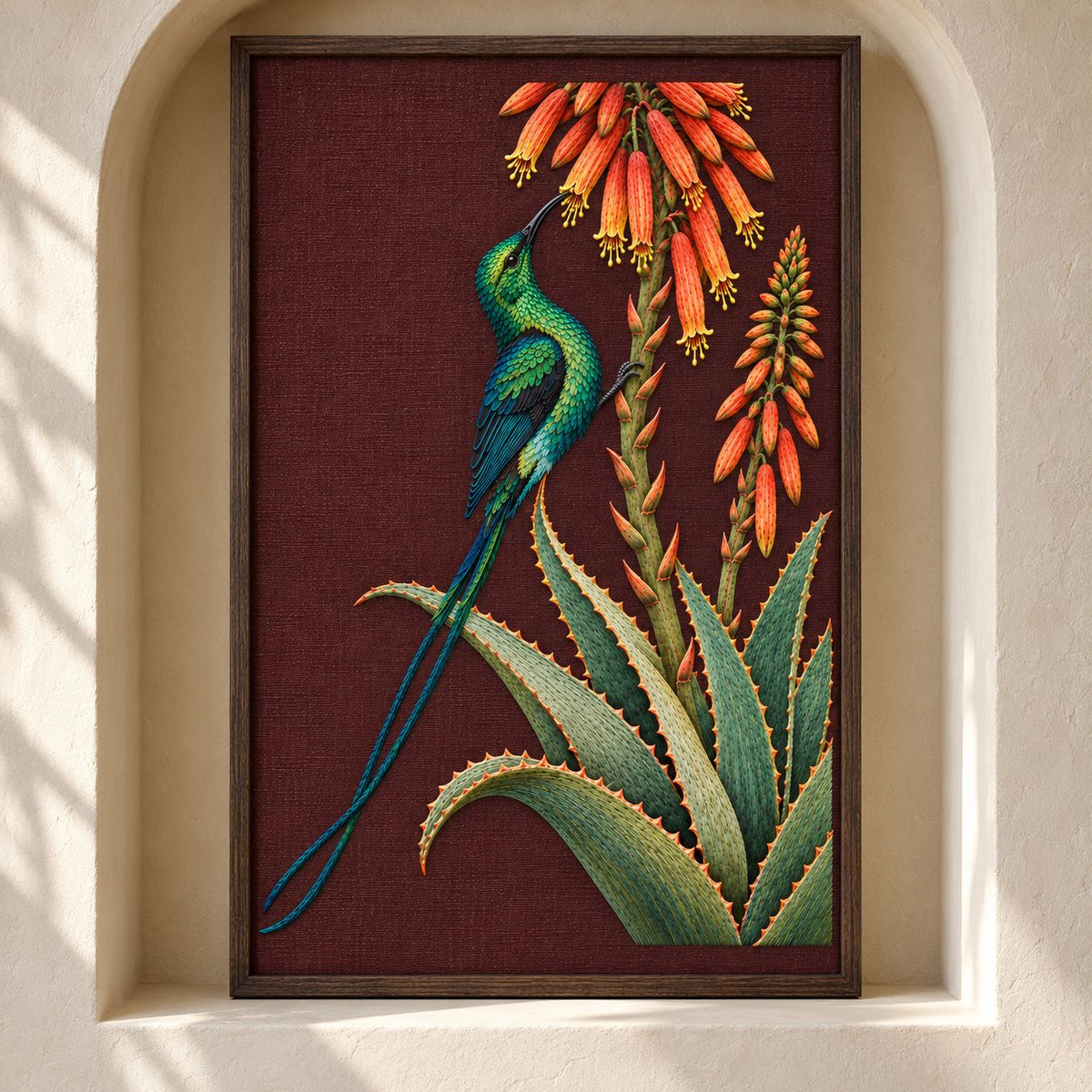 Sunbird at the Copper Aloe visual mockup shown as a framed textile in a gallery niche, with the design on dark burgundy linen.