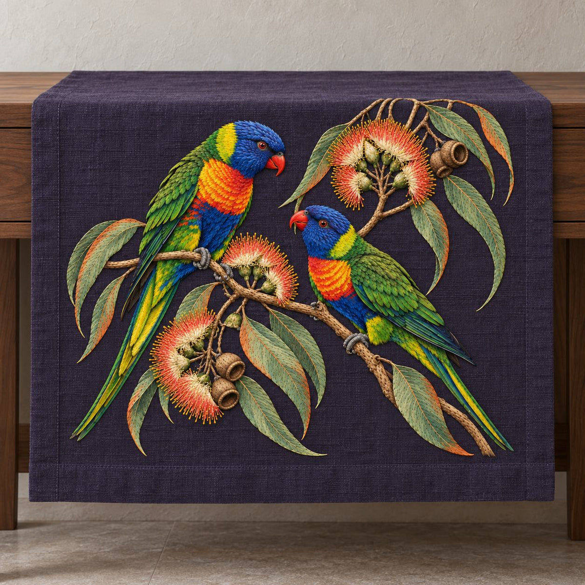 Lorikeet Across the Eucalyptus Fire visual mockup shown on a textile runner over a console, with the design on deep violet linen.
