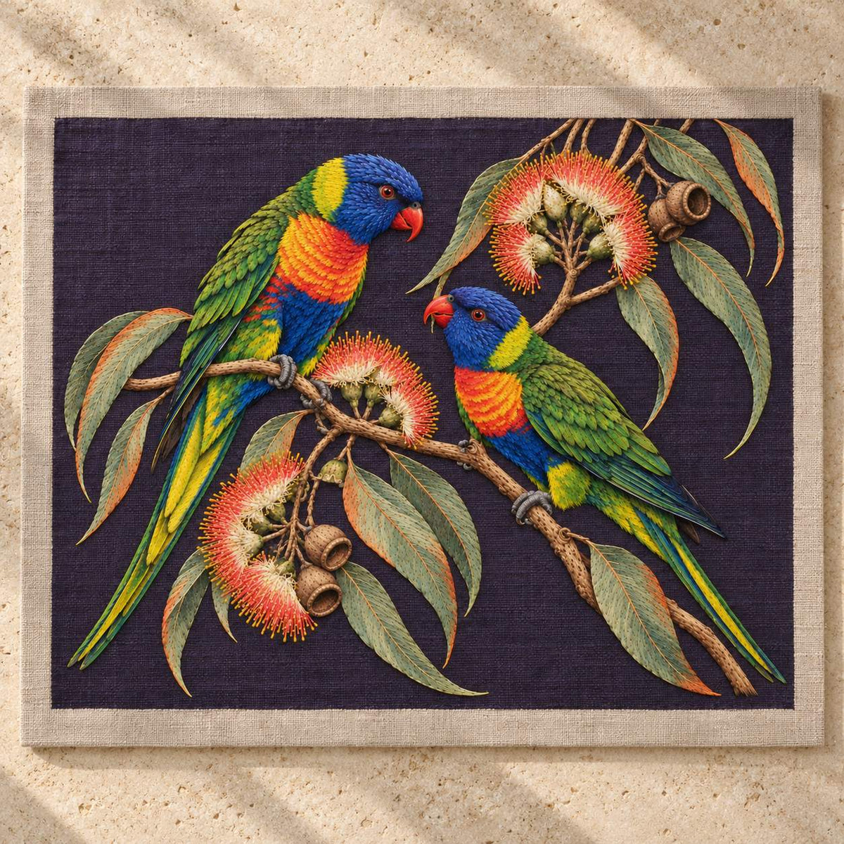 Lorikeet Across the Eucalyptus Fire visual mockup shown as a textile panel on a stone platform, with the design on deep violet linen.