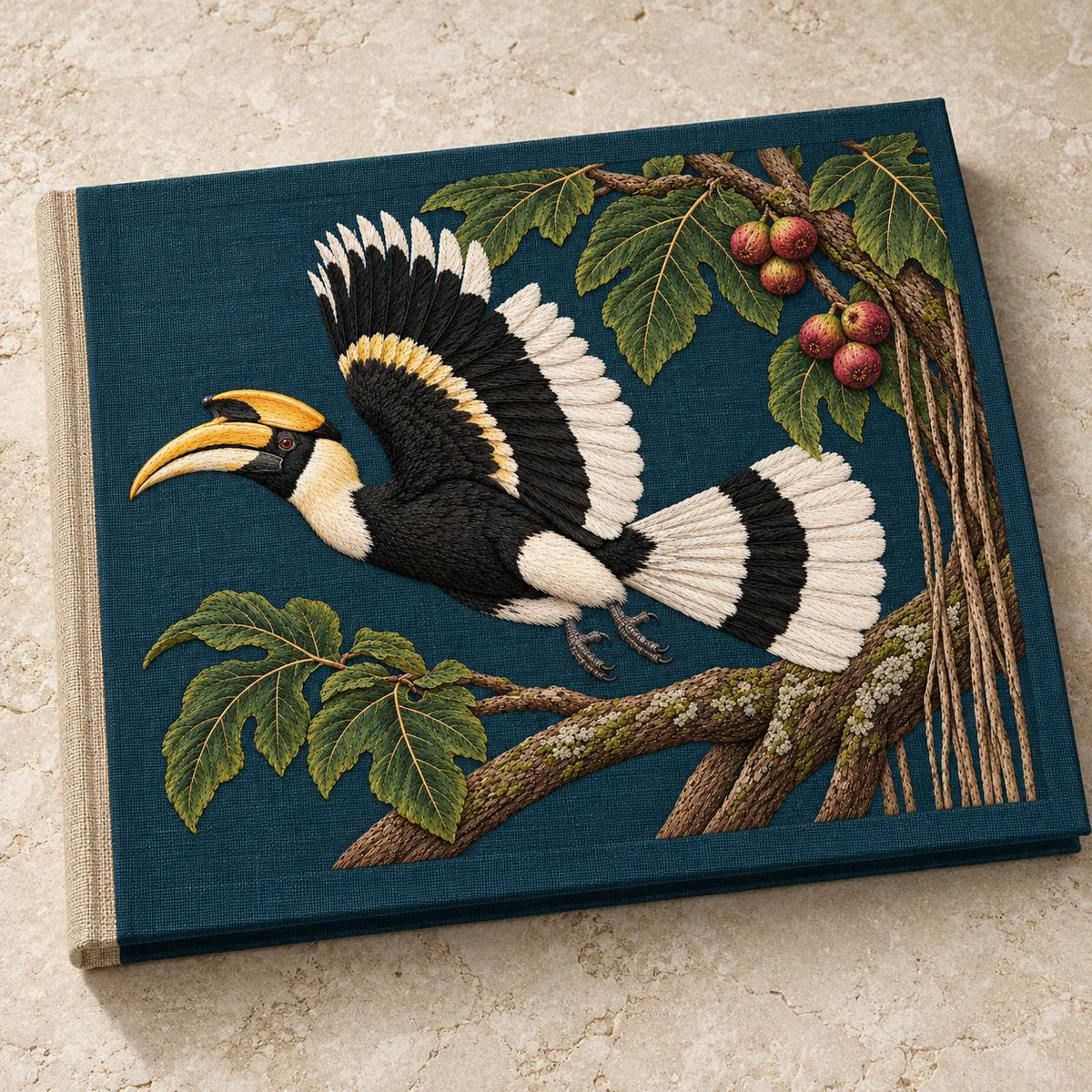 Hornbill Above the Fig Vault visual mockup shown on a cloth portfolio cover, with the design on deep teal-blue linen.