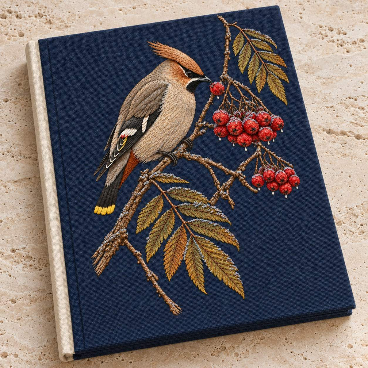 Waxwing at the Frozen Rowan Cluster visual mockup shown on a cloth portfolio cover, with the design on deep navy linen.