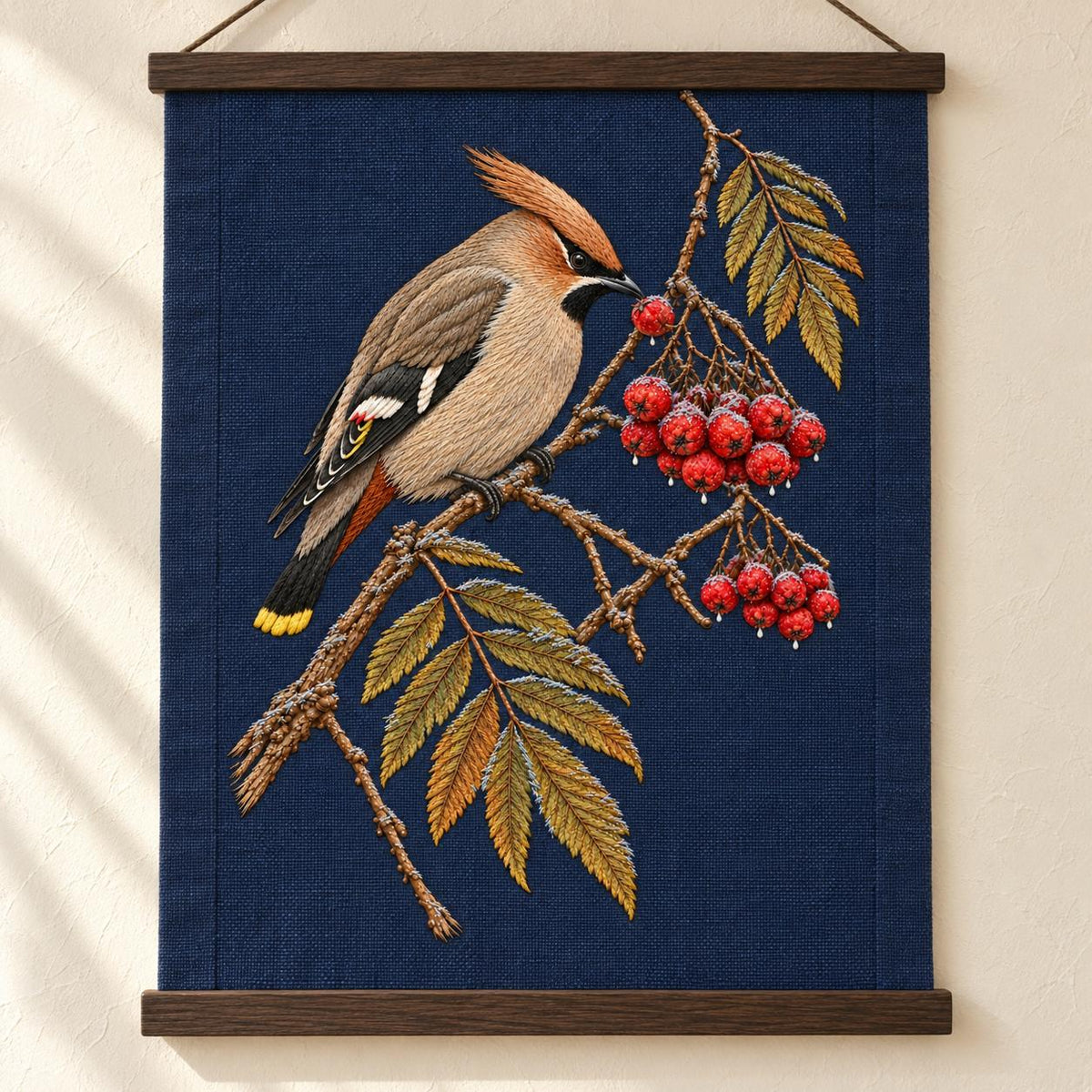 Waxwing at the Frozen Rowan Cluster visual mockup shown as a hanging textile held by wooden rails, with the design on deep navy linen.
