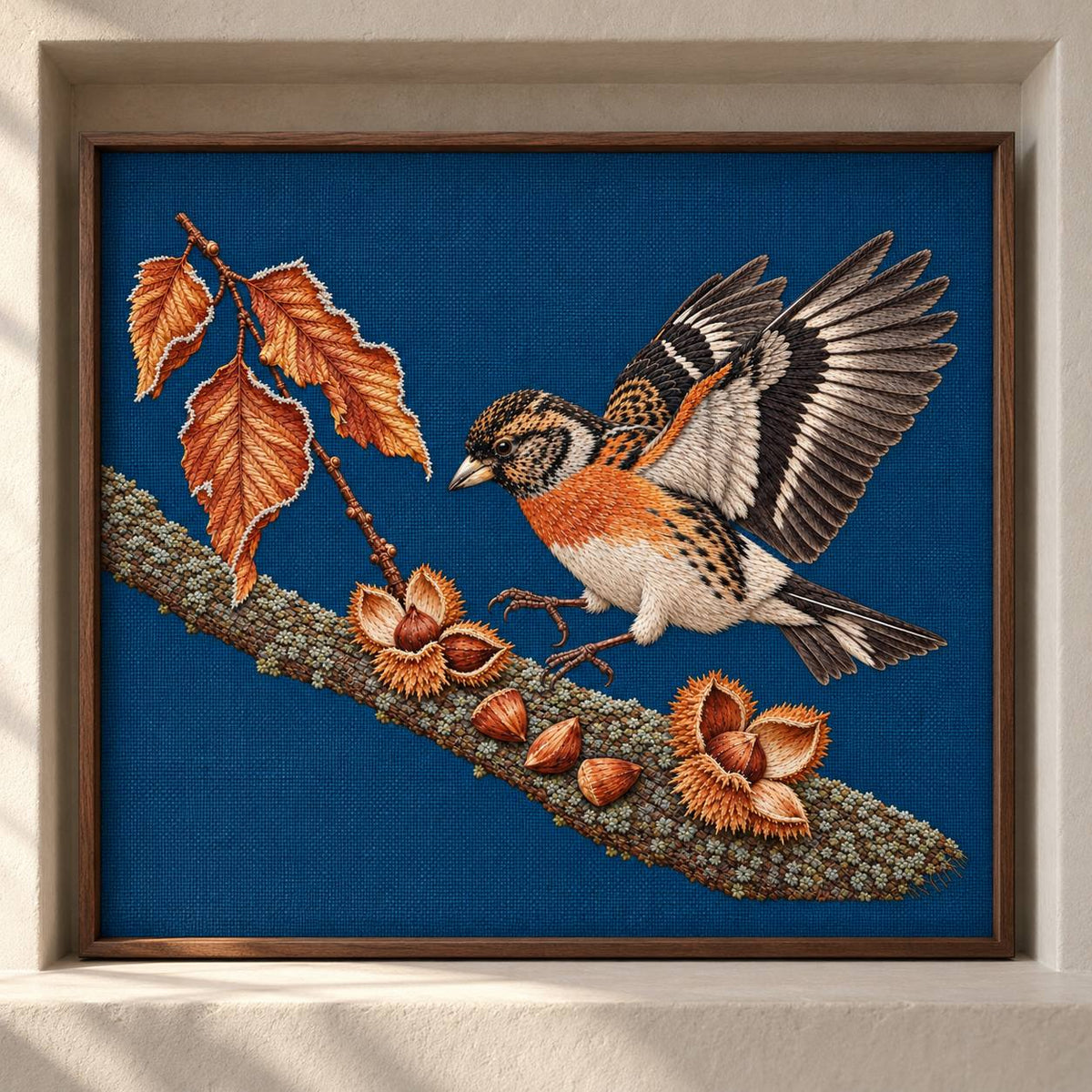 Brambling Above the Frosted Beech Mast visual mockup shown as a framed textile in a gallery niche, with the design on deep-blue linen.