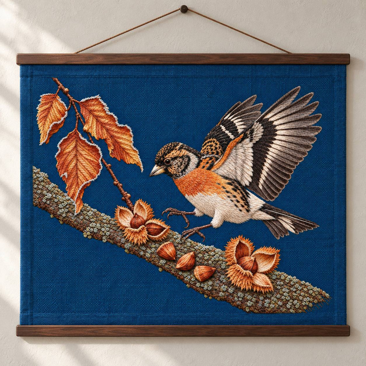 Brambling Above the Frosted Beech Mast visual mockup shown as a hanging textile held by wooden rails, with the design on deep-blue linen.