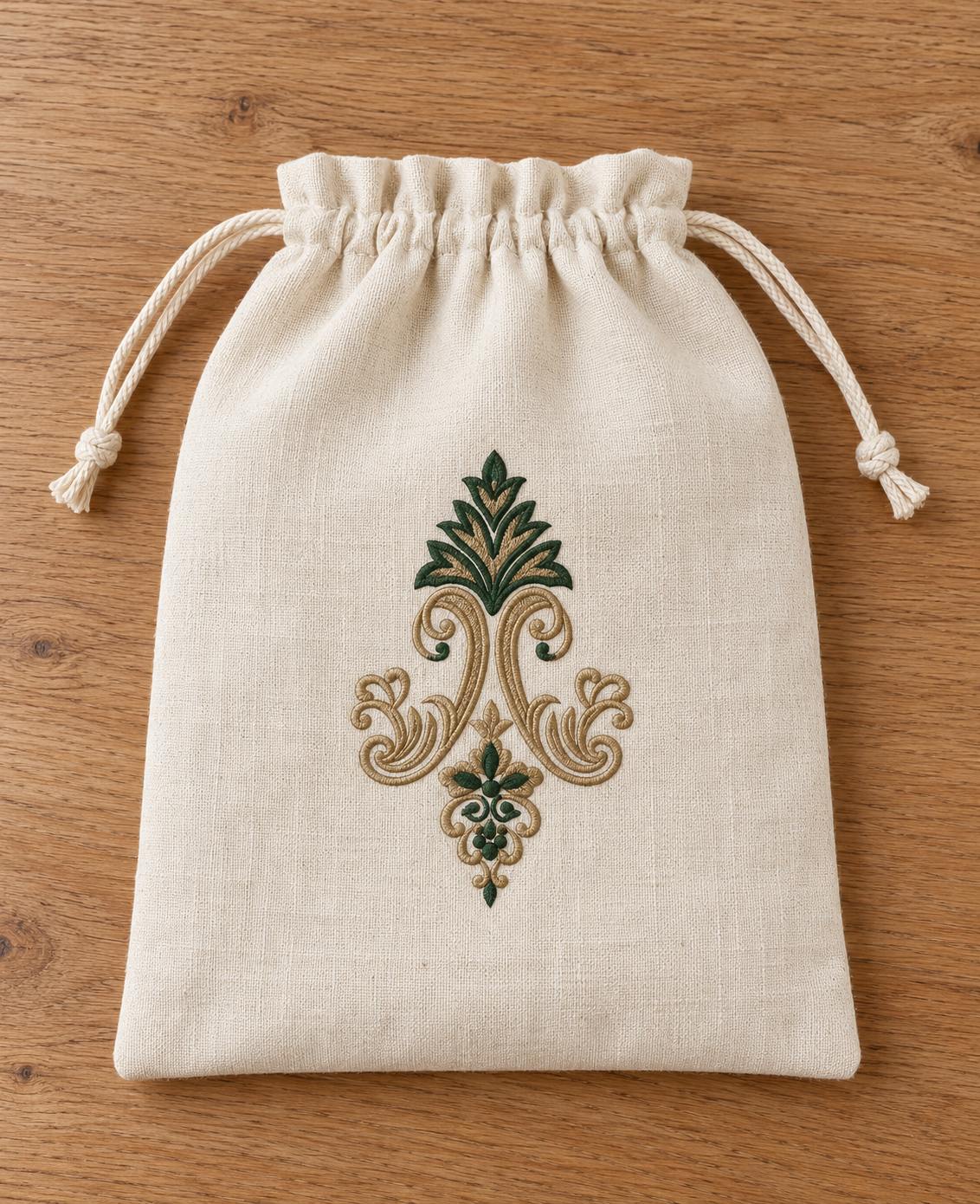 Acanthus Crown Floral Drop embroidered in parchment and forest green on a linen drawstring pouch, showing the complete two-color motif.