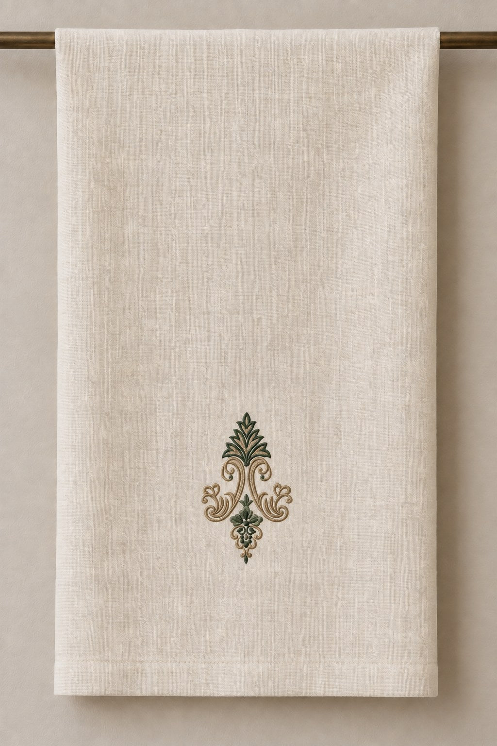 Acanthus Crown Floral Drop embroidered in parchment and forest green on a linen guest towel, showing the complete two-color motif.