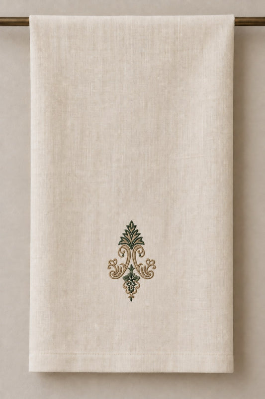Acanthus Crown Floral Drop embroidered in parchment and forest green on a linen guest towel, showing the complete two-color motif.