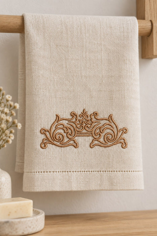 Antique bronze mirrored scroll machine embroidery stitched on a folded white guest towel