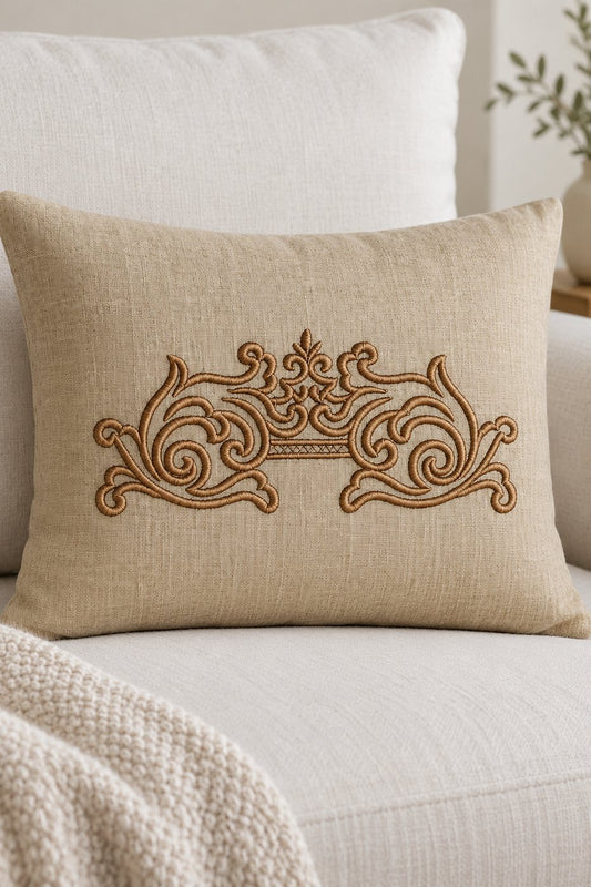 Single-color antique bronze mirrored scroll machine embroidery on a pale flax lumbar cushion