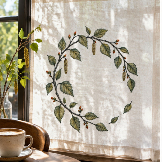 Hanging leaf wreath mockup featuring the Birch Leaf Open Wreath hand embroidery design. Young birch branches and hanging catkins form a light wreath with a lower-right gap.
