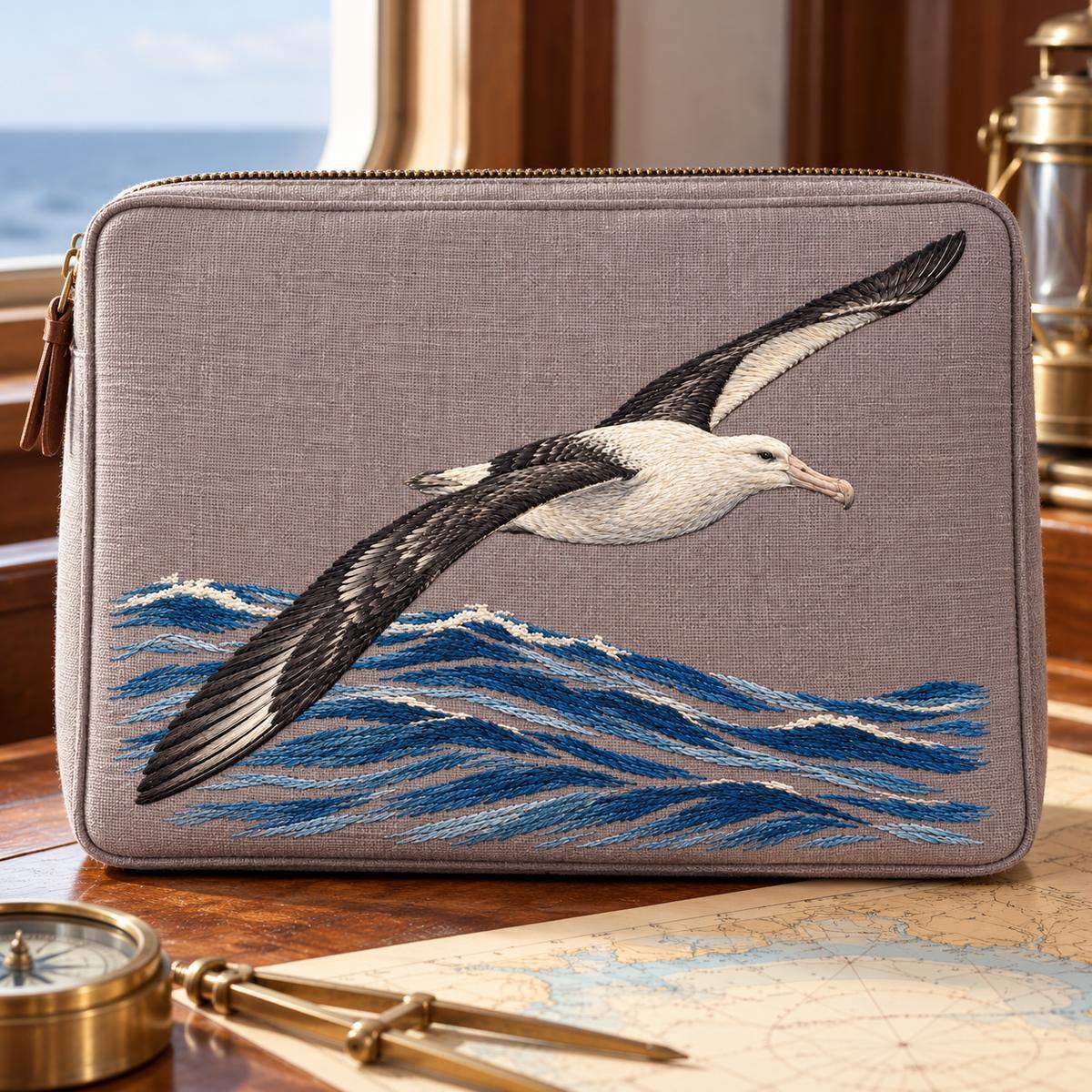 Albatross embroidery design in a digital mockup of broad rectangular nautical chart case standing on a captain's table. Placement inspiration for Study 03.