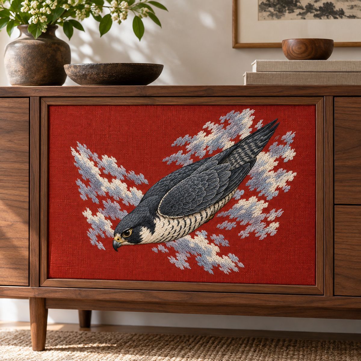 Peregrine Falcon embroidery design in a digital mockup of wide red linen cabinet-front insert in a minimalist walnut furniture piece. Placement inspiration for Study 04.