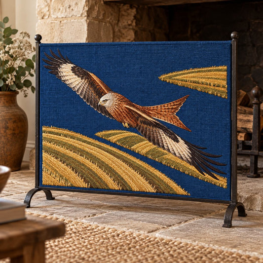 Kite embroidery design shown in a digital mockup of A wide indigo embroidered firescreen panel in a simple black iron stand beside an unlit stone farmhouse hearth. Study 05.